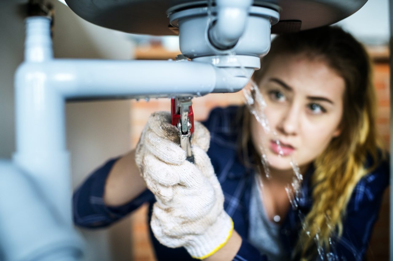 Woman Fixing Kitchen Sink